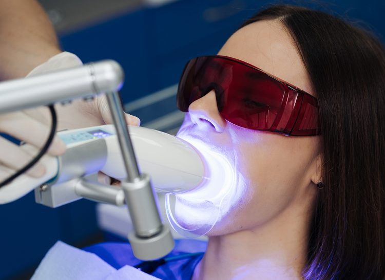 Close-up portrait of a female patient visiting dentist for teeth whitening in clinic